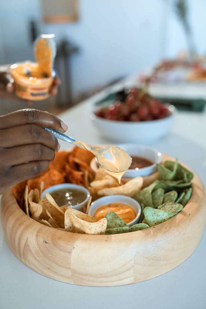 Delicious snack platter featuring mixed chips and sauces, perfect for parties.